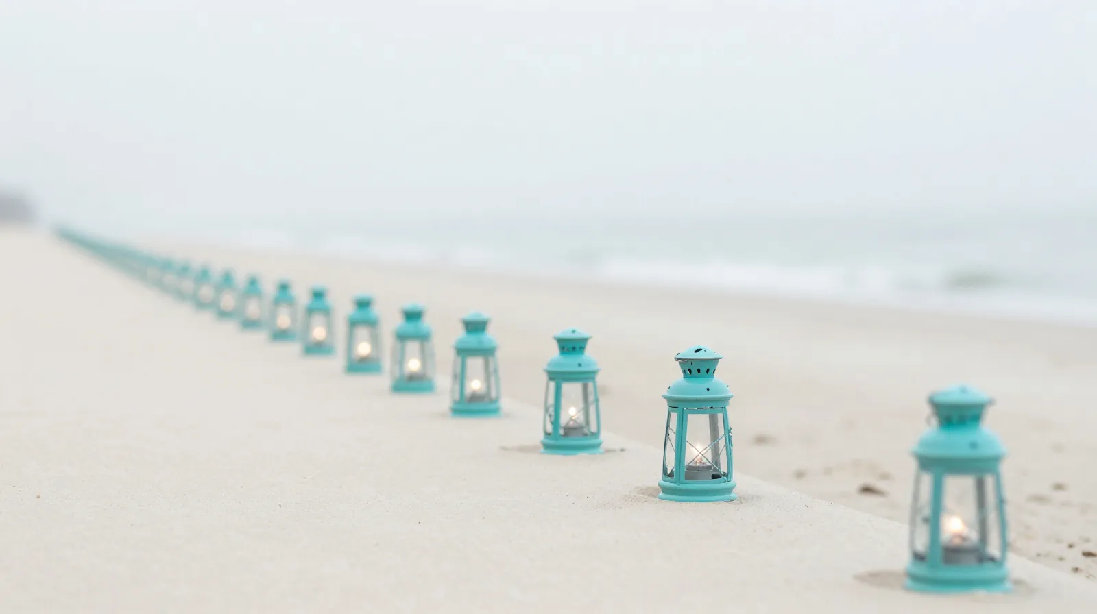 A row of small lanterns along a bright path, growing fainter until the last ones are dark